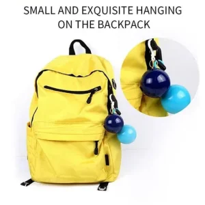 Portable raincoat keychain ball clipped securely to a backpack strap